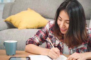 Young girl writing on notepad