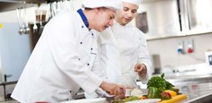 Chef and apprentice practising food safety