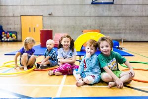 Smiling children sitting on gym floor