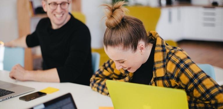 man and woman laughing together at work