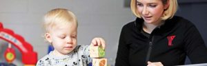 YMCA Child Care Staff playing with young child and blocks