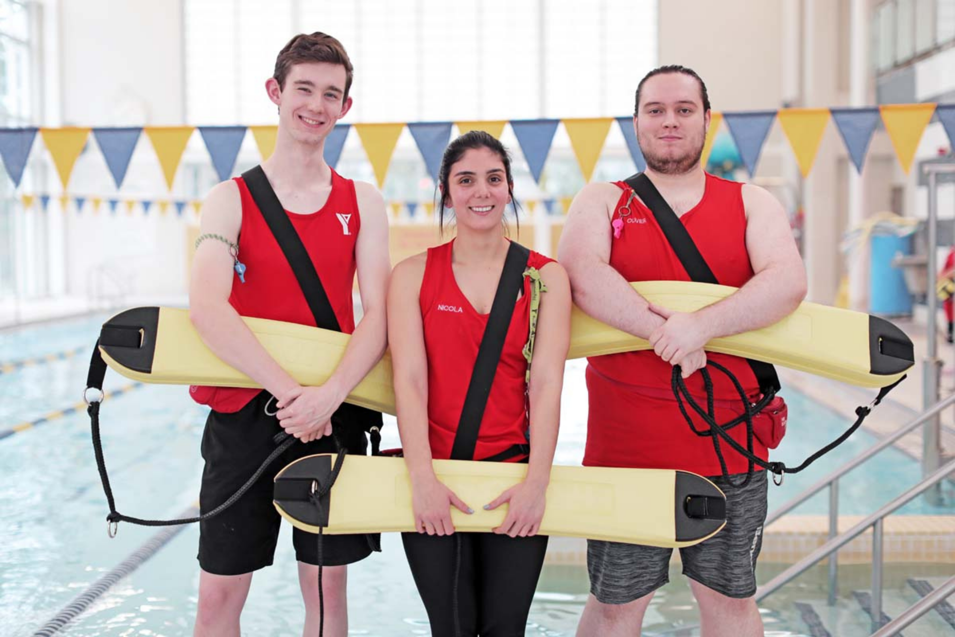 3 YMCA Lifeguards standing in front of pool